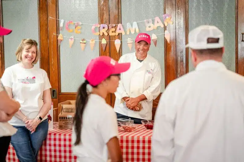 Volunteers smiling and serving ice cream at the Freedom from Hunger Drive ice cream bar during the Valley Forge Tourism & Convention Board kickoff event in Pottstown.