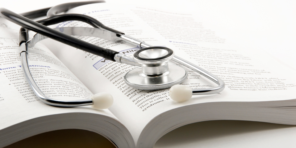 A stethoscope on top of an open book.