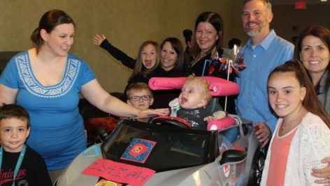 Axalta employees and their children build cars to help toddlers with mobility challenges.