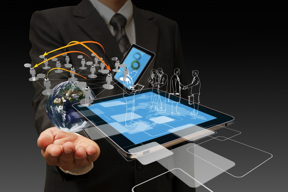 A man in a business suit with holographic images of the world and people in front of him.