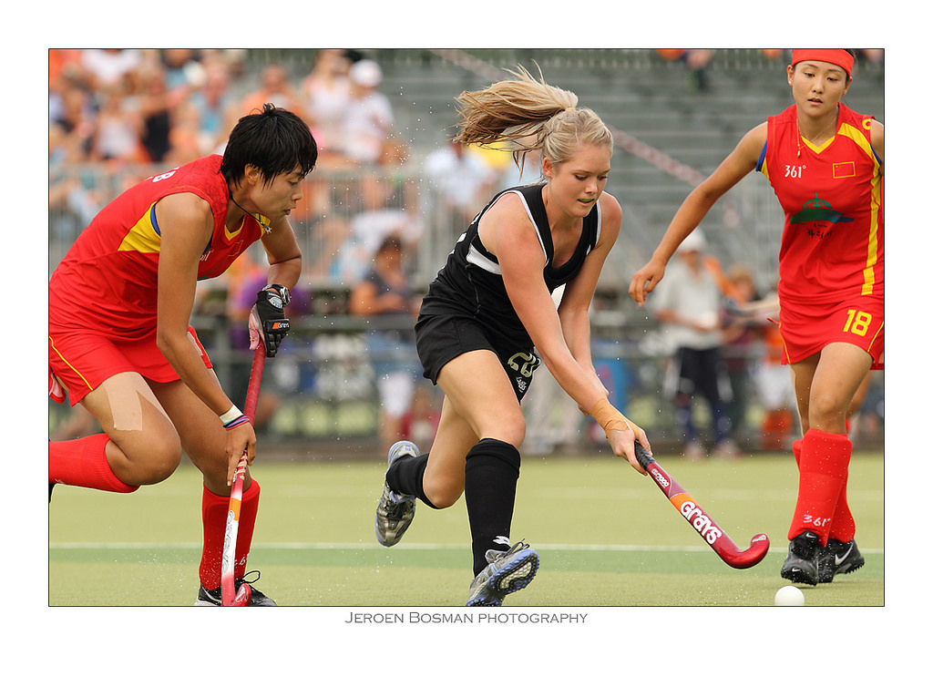 Women playing field hockey