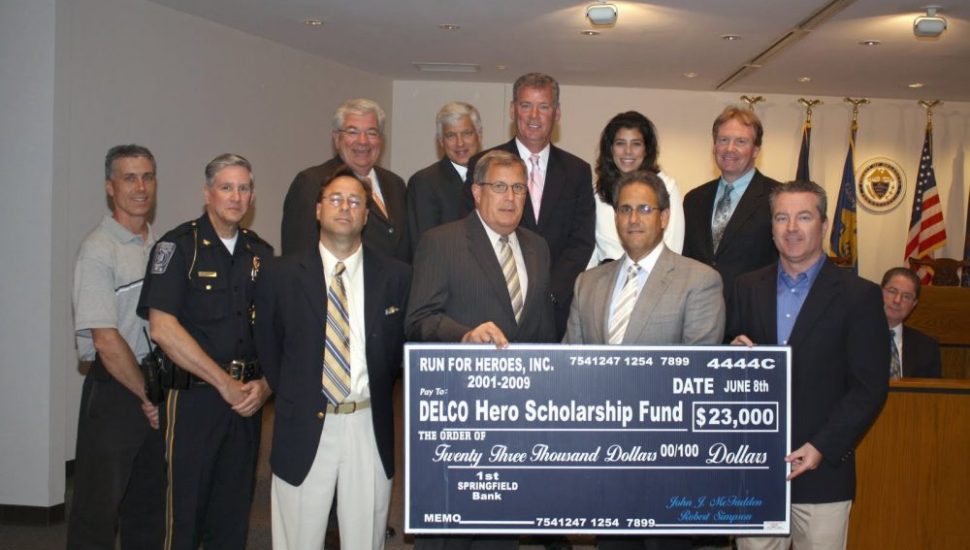 A group of people holding a large check from the Run for Heroes and the Delaware County Hero Scholarship Fund.