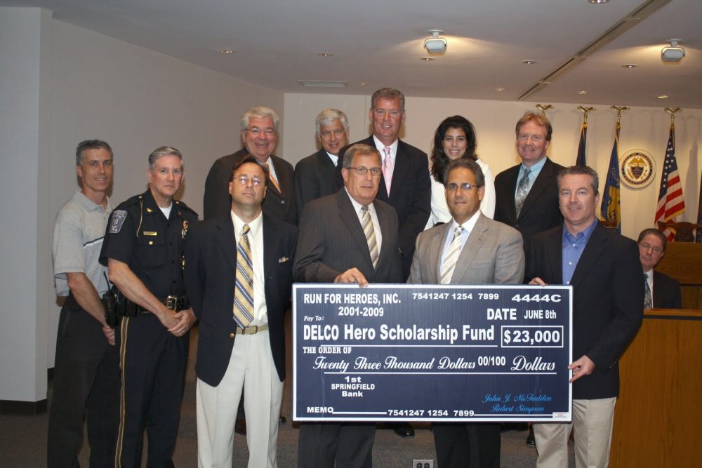 A group of people holding a large check from the Run for Heroes and the Delaware County Hero Scholarship Fund.