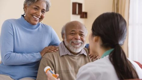 A nurse talking with an older couple about medicines.