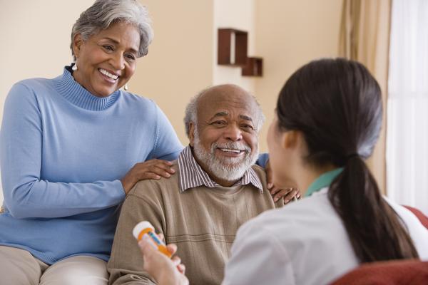 A nurse talking with an older couple about medicines.