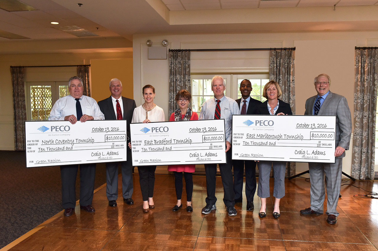 Township representatives hold big checks, donations from PECO