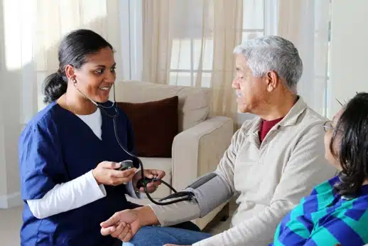 A nurse taking the blood pressure of a man.