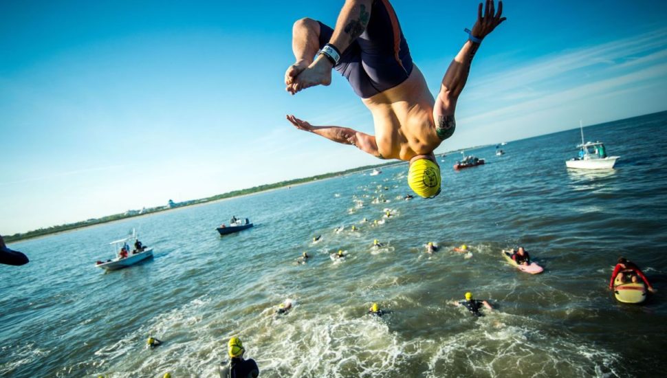 A man jumps off the Cape May Lewes Ferry into the ocean to start the Escape the Cape Triathlon.
