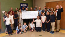 Participants and supporters of an outdoor education program hold a giant check representing a PECO grant for the program.