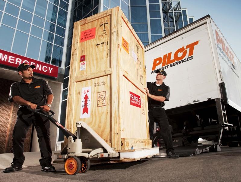 A Pilot truck and two Pilot workers making a delivery.