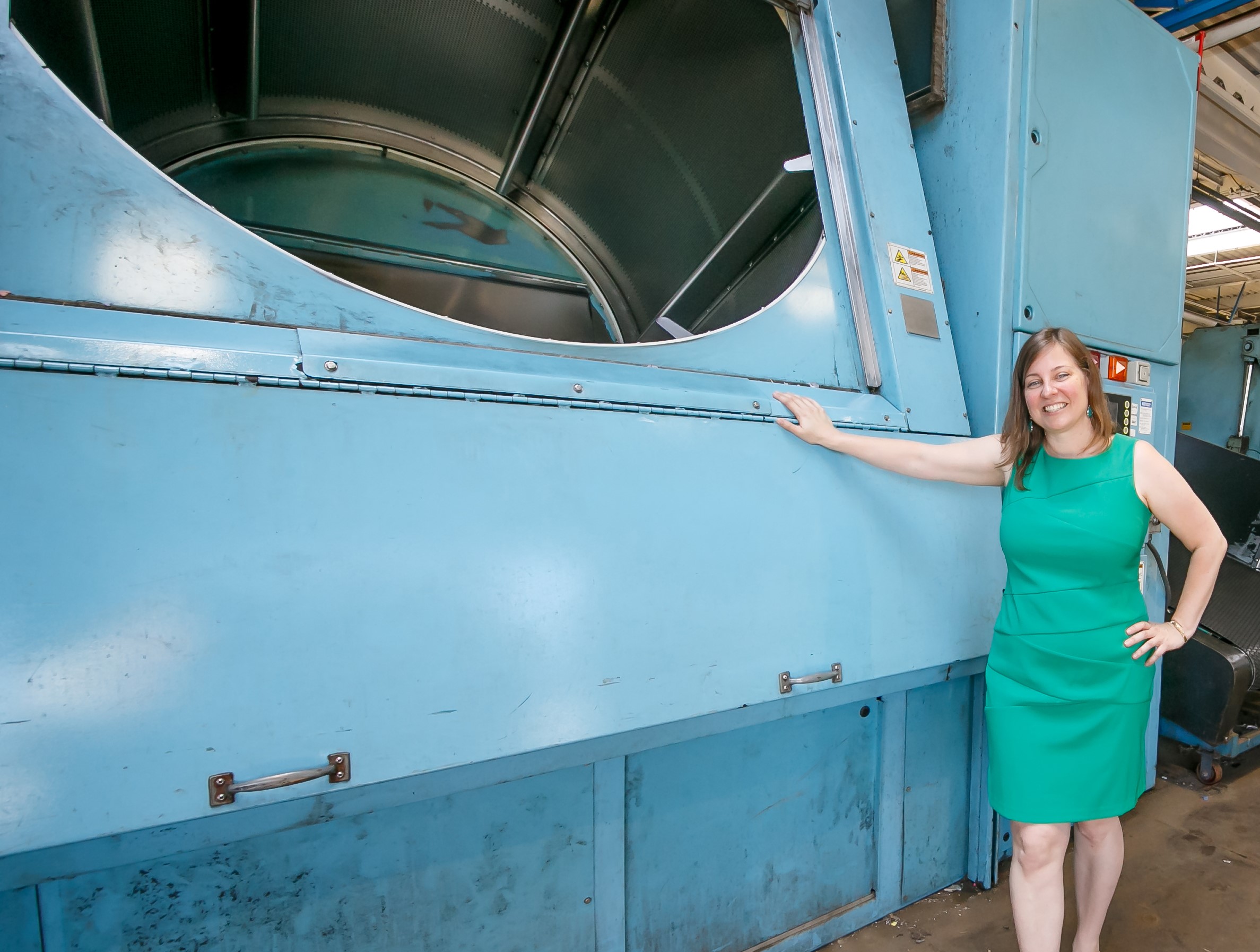 A woman next to a an industrial rubber mat cleaner.