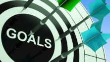 A graphic of dart board with darts sticking into it and the word "goals" at the center.