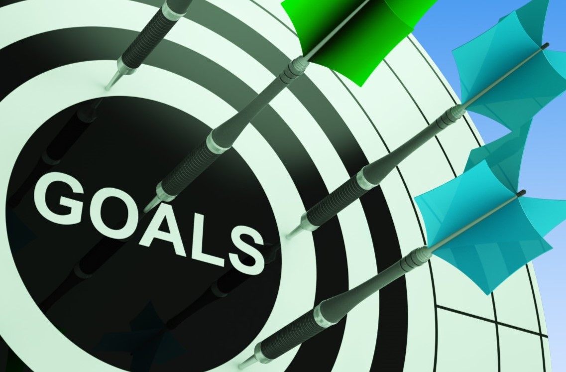 A graphic of dart board with darts sticking into it and the word "goals" at the center.