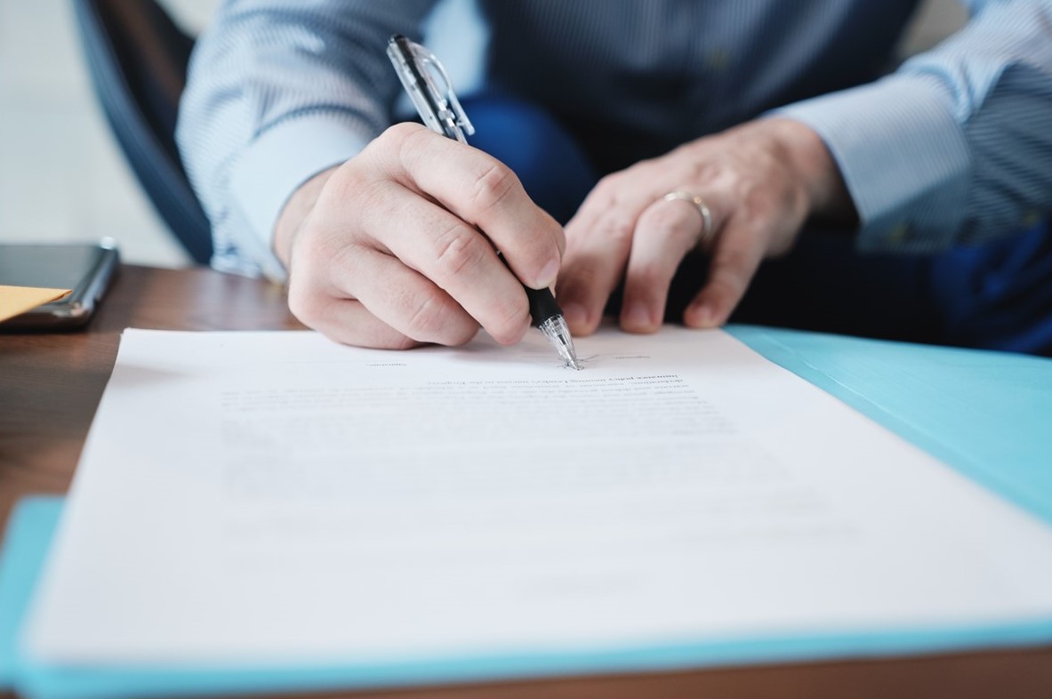 Man at a desk writing on a document.