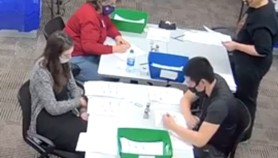 Ballot counters in the foreground are being watched by bipartisan observers at another table in this live feed screenshot from the Delaware County Bureau of Elections.