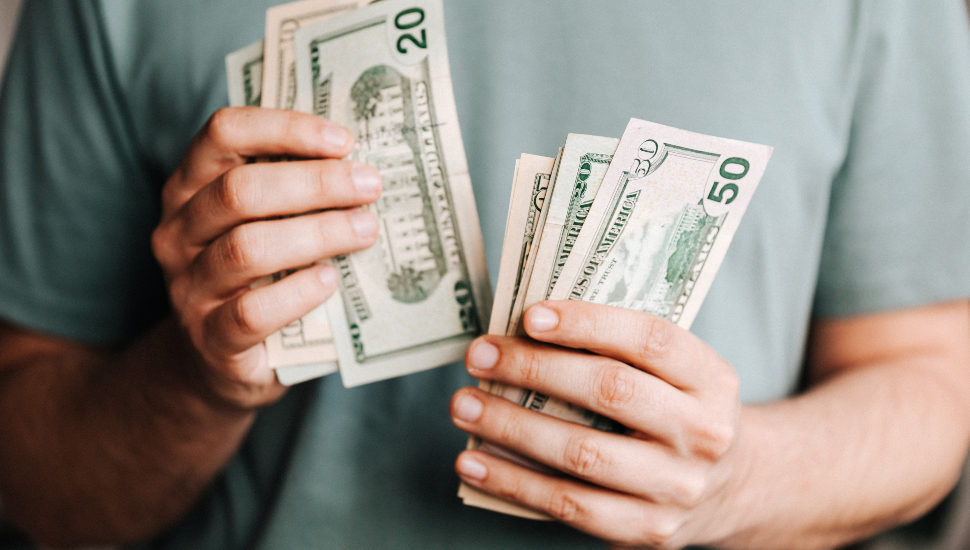 A man holding cash in his hands.