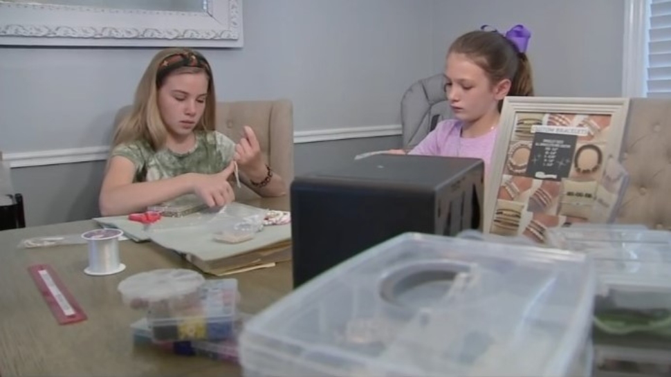 Ava DeGuio (left) and Sophia De Guio in Dreel Hill assemble a Delco Beads bracelet.
