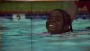 Little girl swimming in a pool.