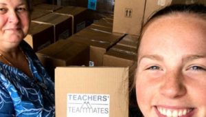 Teachers’ Teammates founder Raelyn Harman works with volunteer Emily Markley carrying classroom supplies.