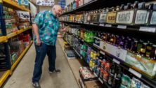 A man buying liquor at a bottle shop in East Falls.