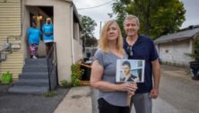 Heather and Larry Arata with a photo of their son Brendan outside a Chester sober house with Tyesha Soto (left) and Tashina Wright in the doorway.