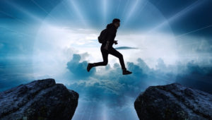 Man jumping from one mountaintop to another