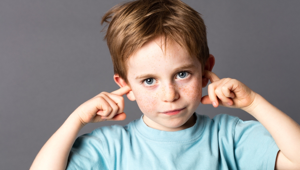 Boy plugging his ears.