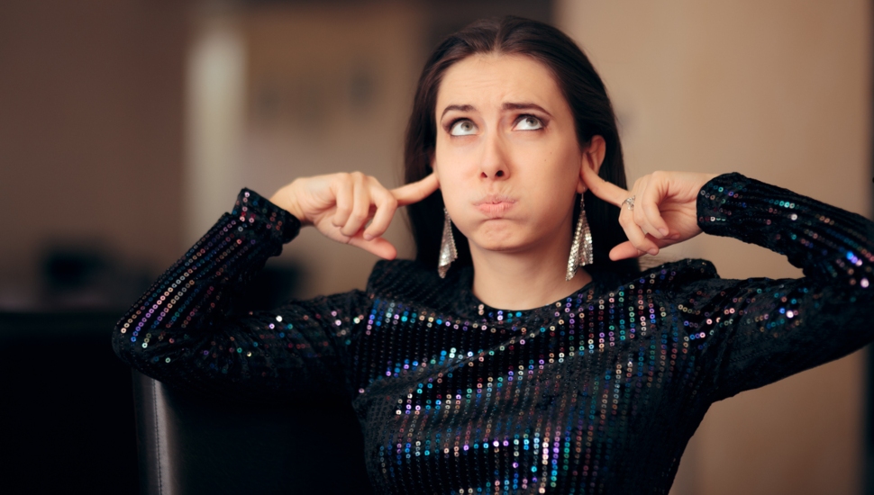 Woman with her ears plugged.