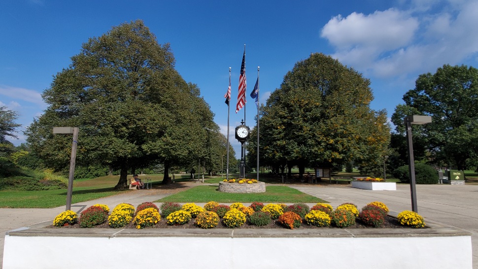The pedestrian walkway with an American flag and planted flowers at Rose Tree Park