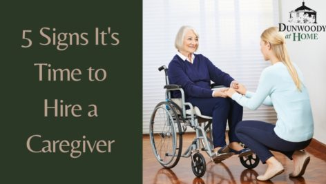 A caregiver talks with an older woman in a wheelchair.