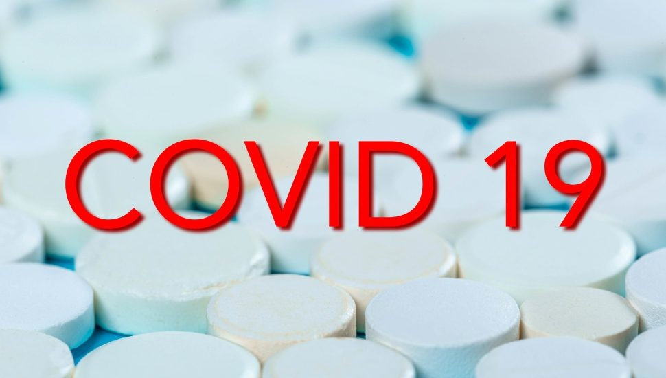 White pills with the words "COVID 19" in red.