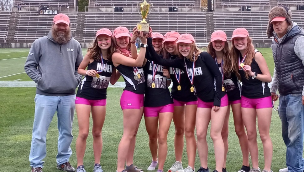 The Strath Haven girls' Cross Country team hold up the district championship trophy.