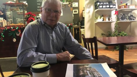 Bill Cumby Jr. sits at Hobbs in downtown Swarthmore with the latest renderings of the 110 Park Avenue Project.