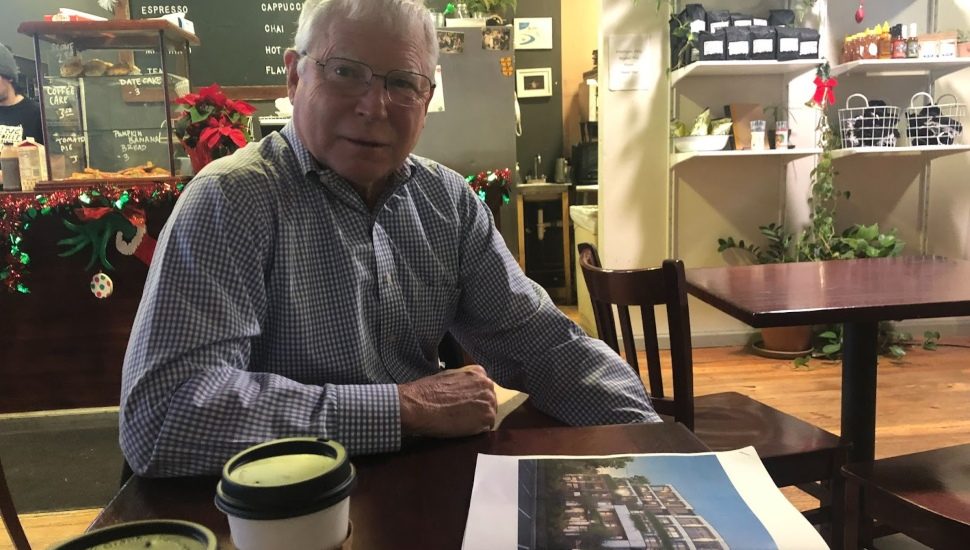 Bill Cumby Jr. sits at Hobbs in downtown Swarthmore with the latest renderings of the 110 Park Avenue Project.