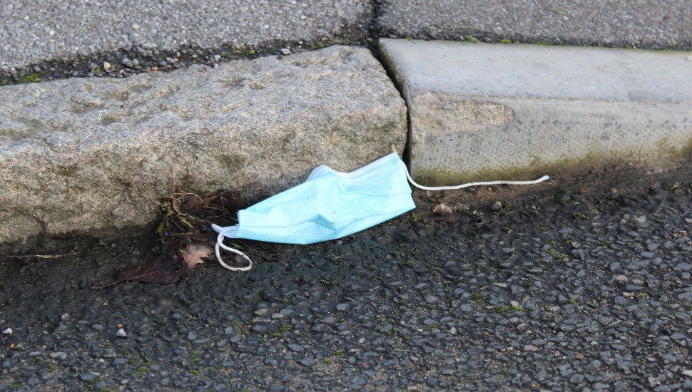 A discarded facial medical mask on the ground