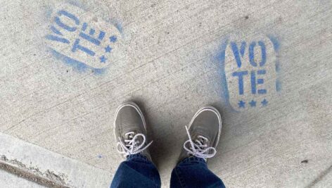 feet on a sidewalk highlighting the redistricting debate.