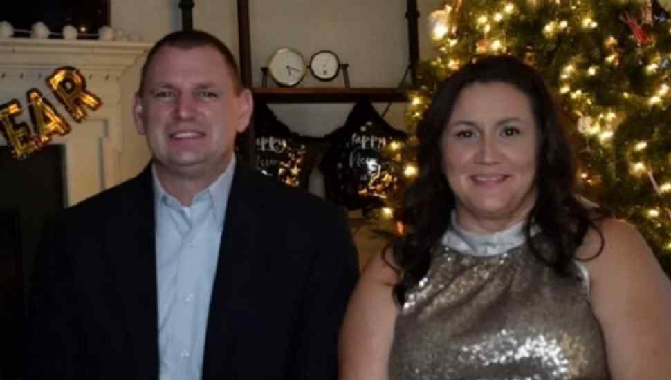 man and woman in front of lighted tree