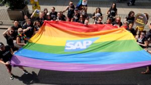 A group from SAP holding a rainbow flag.