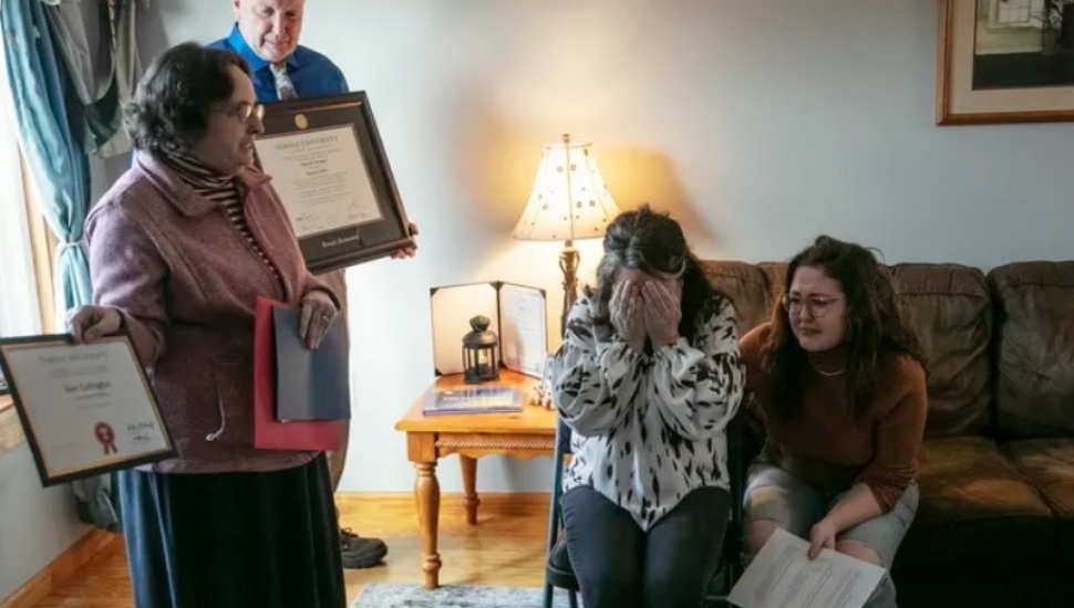 Prof. Robin Kolodny, department chair of political science at Temple, presents a diploma and other honors for Sam Collington at the Collington family home
