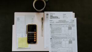Tax forms, a calculator and a cup of coffee on a table