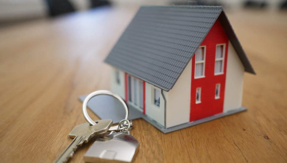 A tiny model house and house keys. symbolizing home ownership and mortgage payments.
