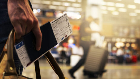 Man carrying a ticket in an airport