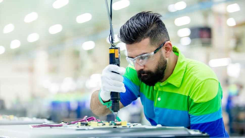 bearded man working a manufacturing job.