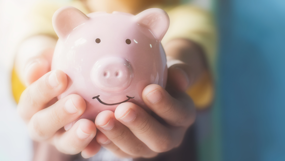 Girl hand holding piggy bank