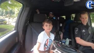 Dominic Glenn rides in a police car.