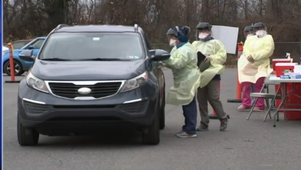 Occupants of a car receive a COVID-19 test from a staff member at the Yeadon Wellness Center.