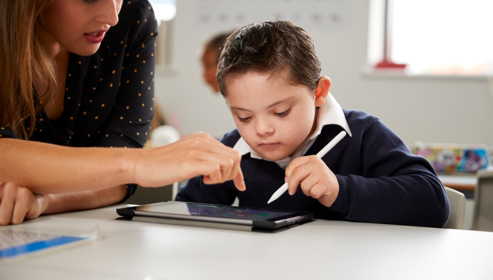 A teacher works with a Down Syndrome child.