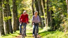 An older man and woman riding bikes on a bike trail