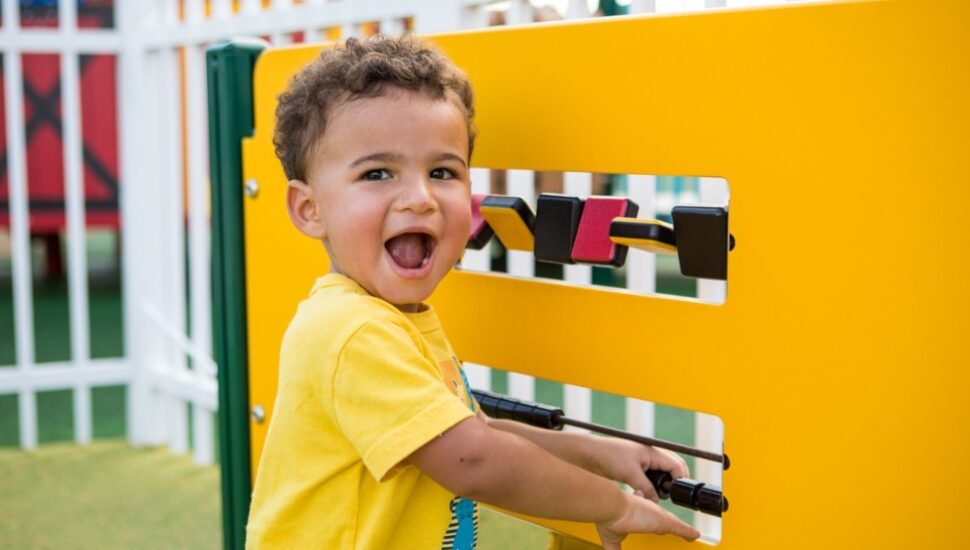 A little boy discovers a piece of playground equipment.