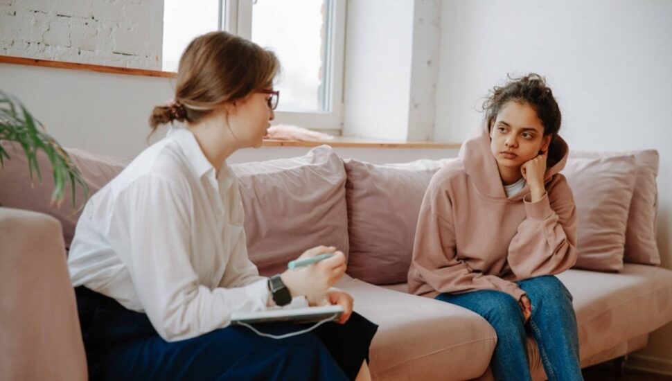 A woman therapist talks with a teenage girl.